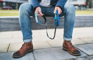 Man sitting alone holding empty dog leash and collar
