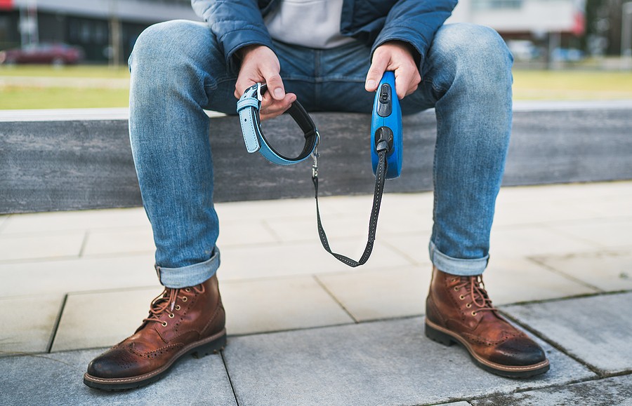 Man sitting alone holding empty dog leash and collar